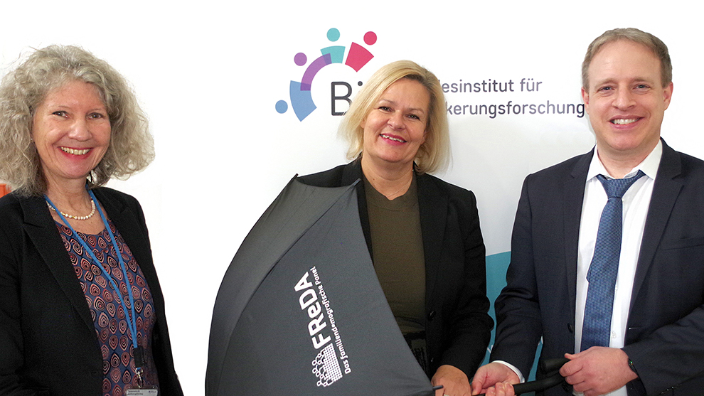 Bundesinnenministerin Nancy Faeser bekommt als Schirmherrin von FReDA von Prof. Dr. C. Katharina Spieß (li.) und Prof. Dr. Martin Bujard symbolisch einen Schirm überreicht.